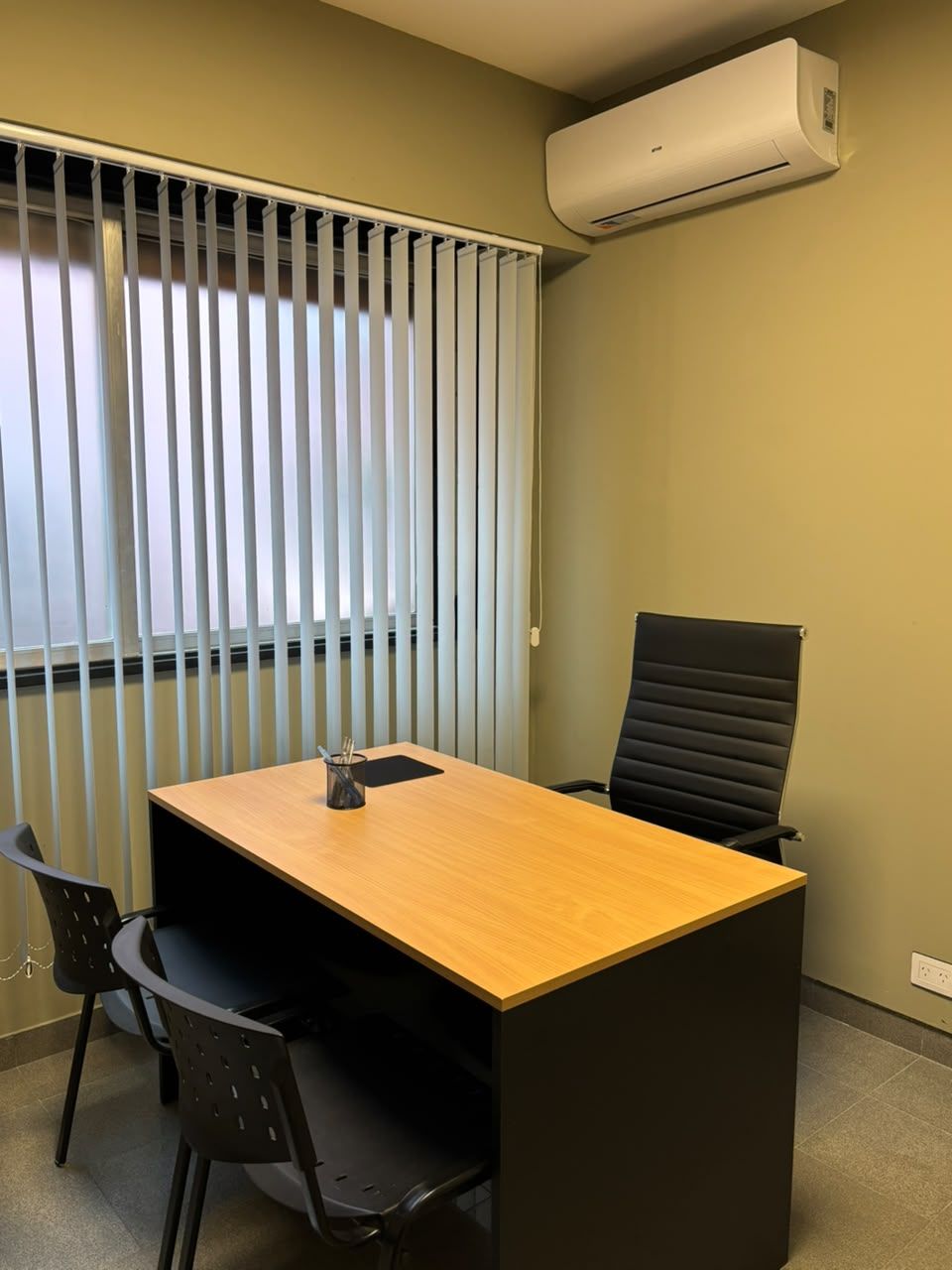 Oficina privada con escritorio y sillas para visitas