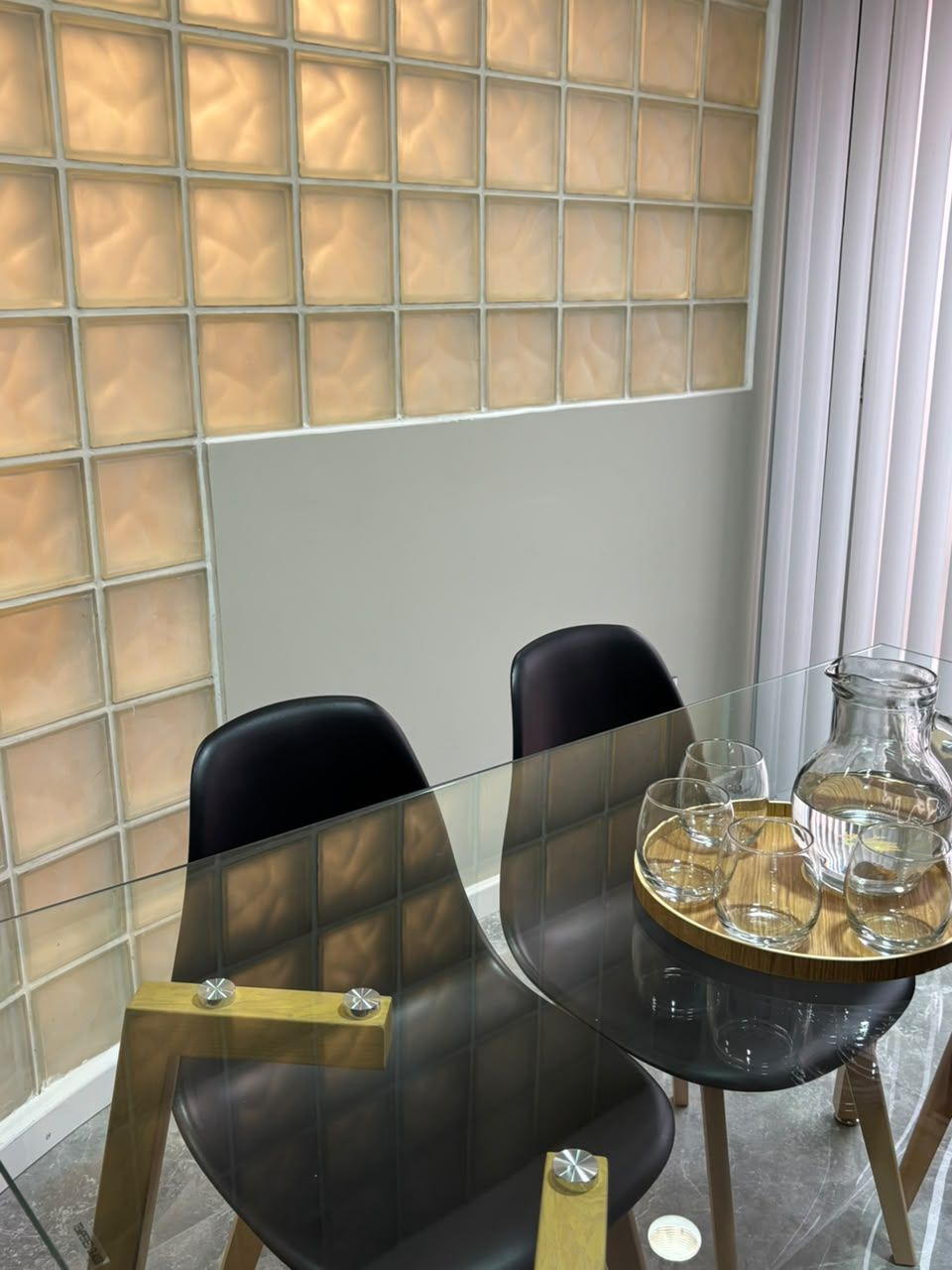 Sala de reuniones con mesa de vidrio y jarra de agua